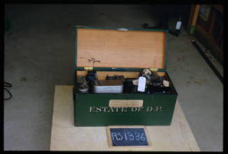 Green wooden storage box containing transformers